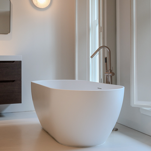 Zilva Barosso gietvloer in badkamer met vrijstaand bad. Vrijstaand bad op Zilva Barosso gietvloer met marmerkorrels in moderne badkamer.