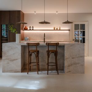 Zilva Barosso gietvloer met marmerkorrels in een moderne keuken met marmeren kookeiland.